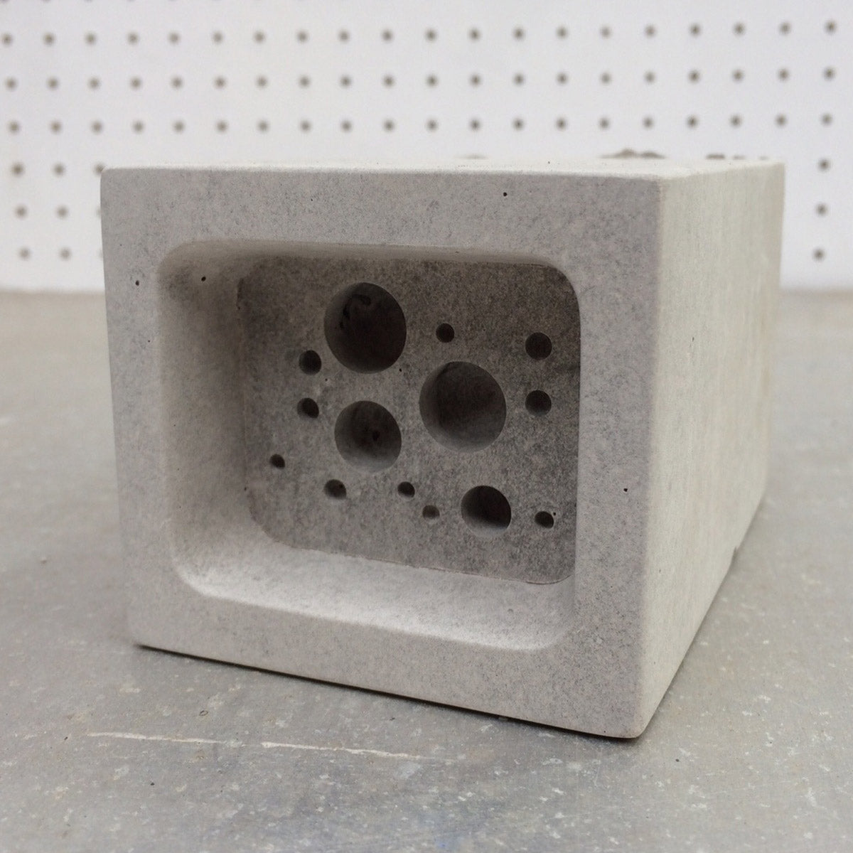 small bee block against pegboard background