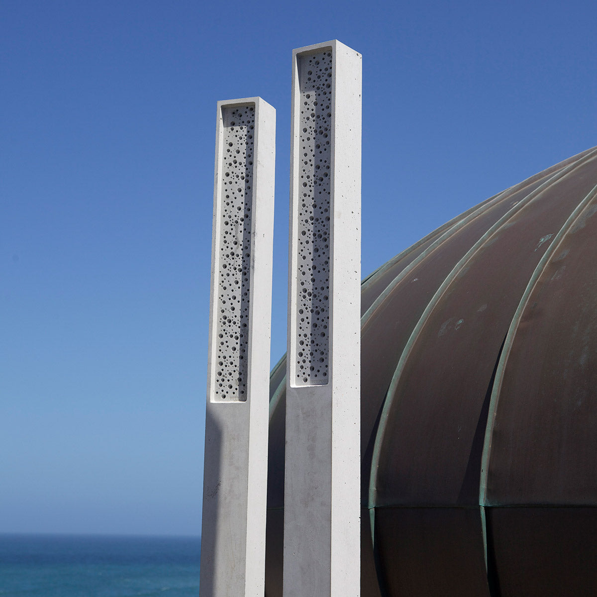 Bee Post bee towers against blue sky and sea